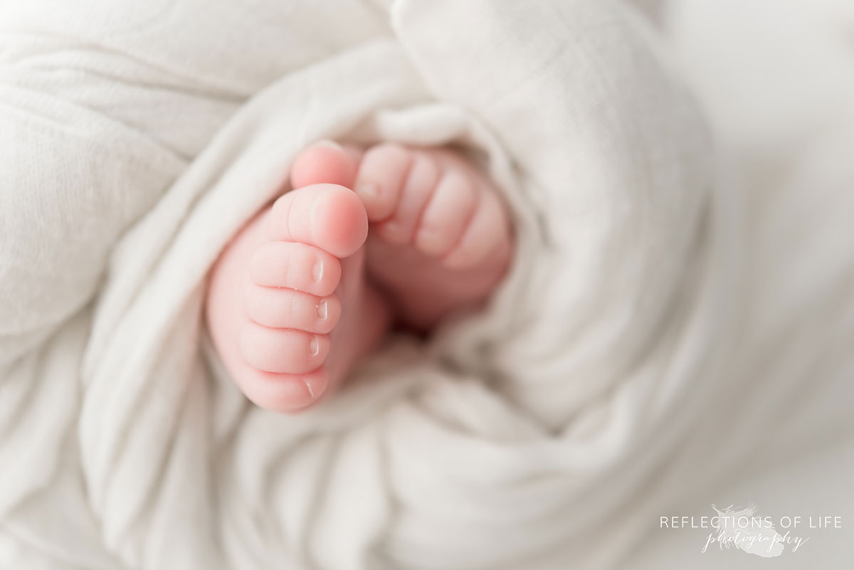 baby boy toes swaddled in white