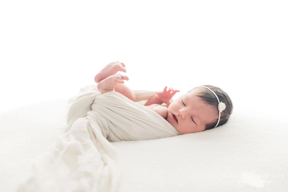 newborn photography of baby wrapped in white
