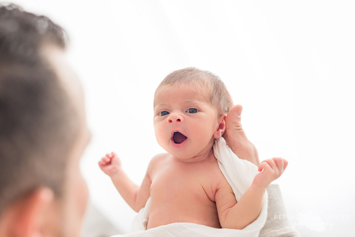 Baby girl yawn in daddys arms