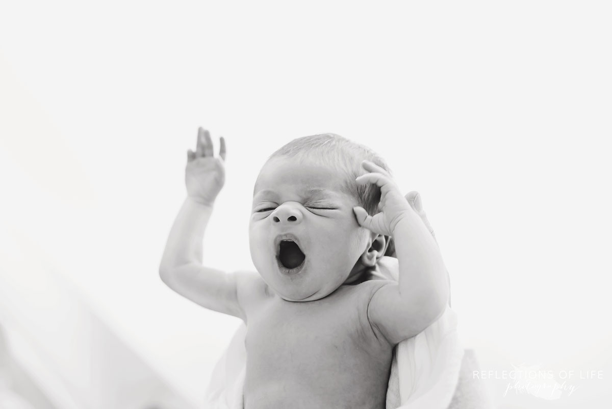 Newborn baby girl yawn in black and white