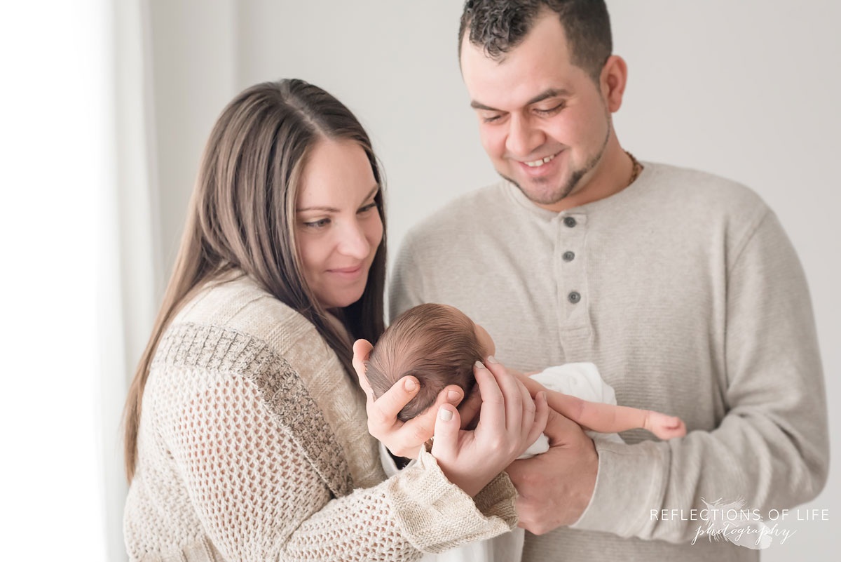 newborn baby girl held by her parents