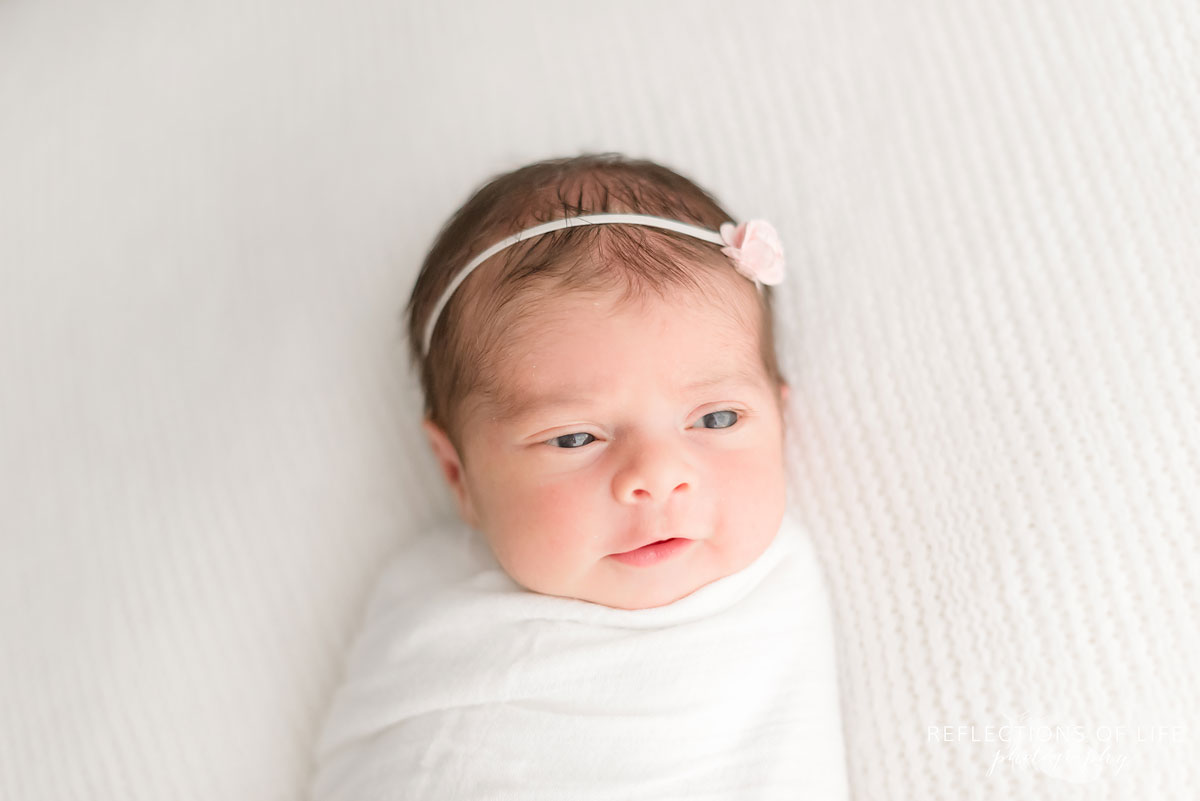 Newborn baby girl smiling with simple headband