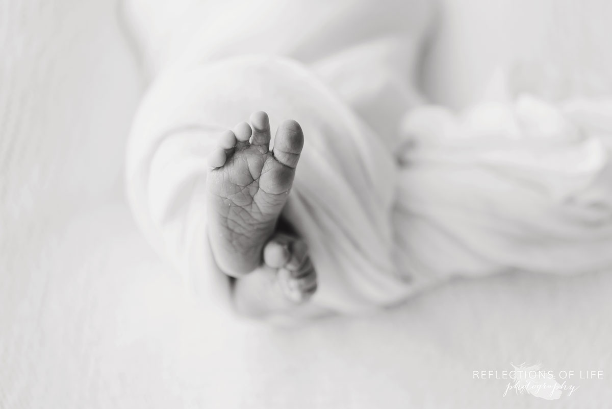 little baby feet wrapped in a white blanket