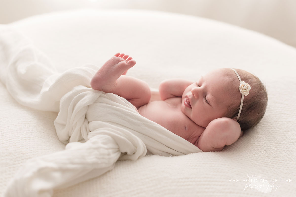 newborn baby girl wrapped in white