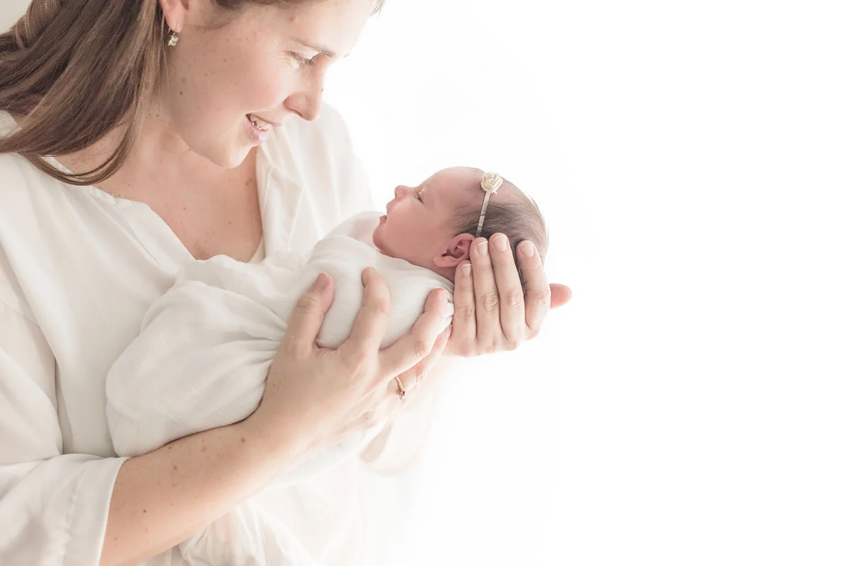 mom holding beautiful baby girl white background.jpg