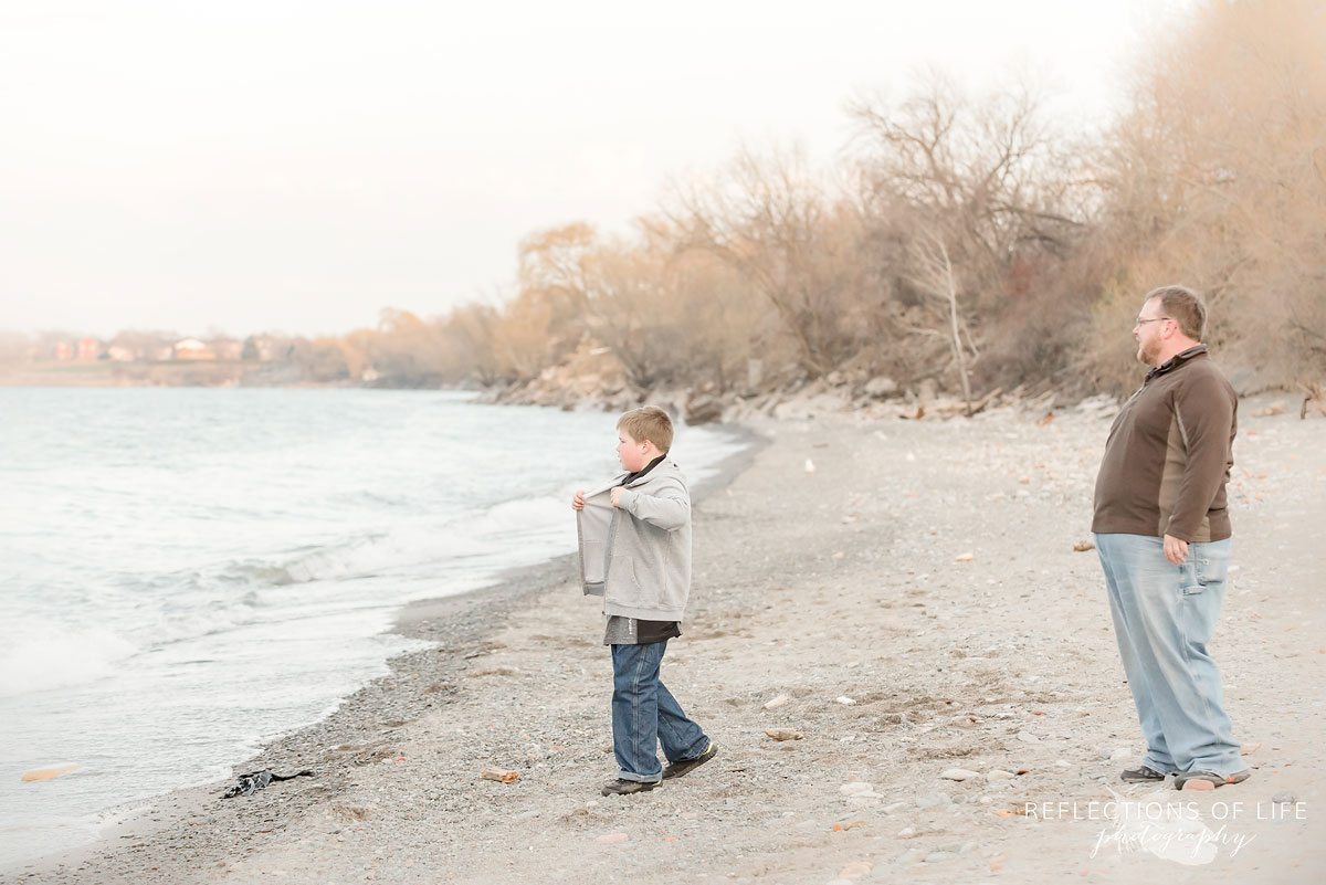 Father and son throwing rocks into the water by Grimsby Beach