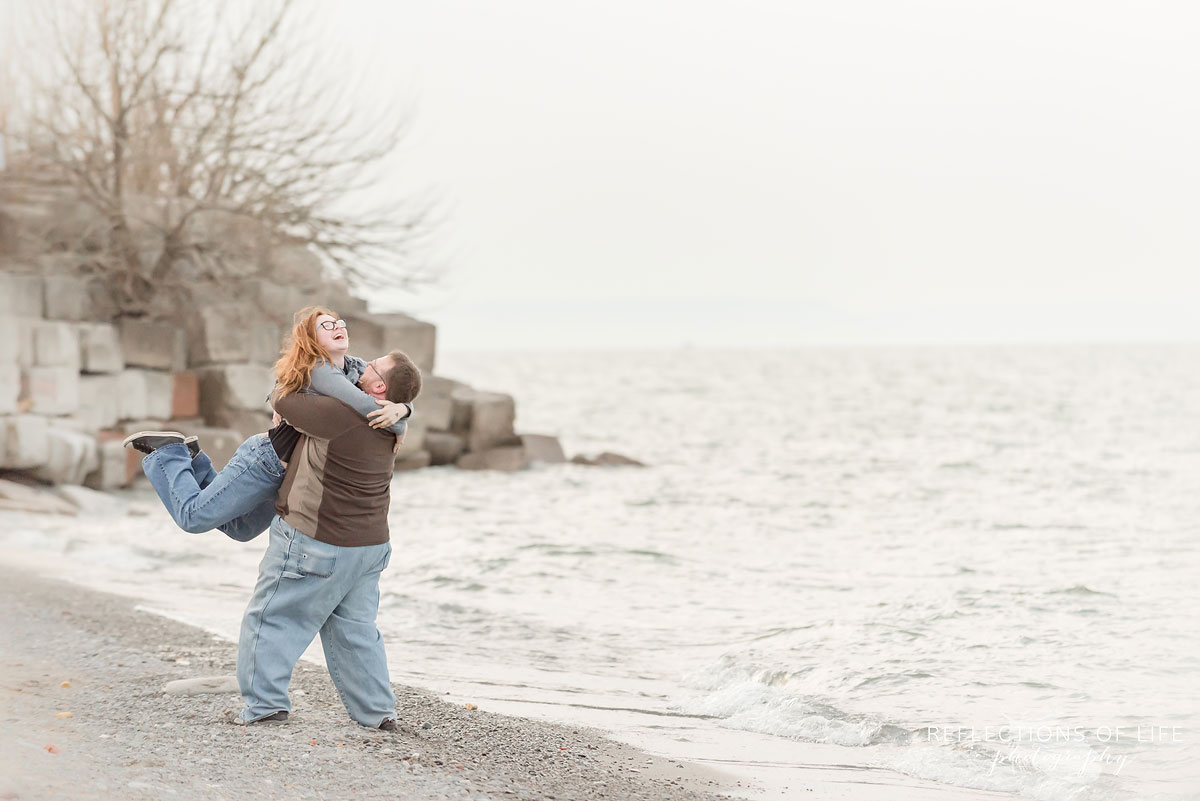 Father lifting daughter up by the beach in Grimsby Ontario