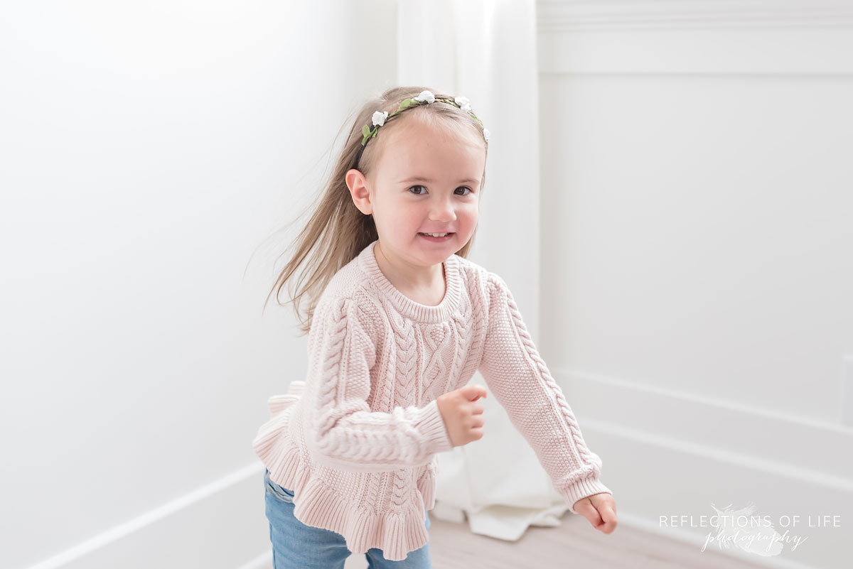 Young girl with a floral headband in white studio