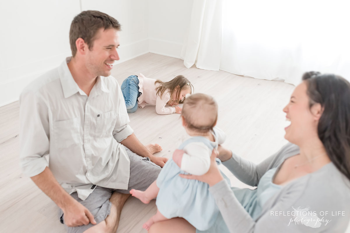 Candid family playing on white floor in studio in Grimsby Ontario