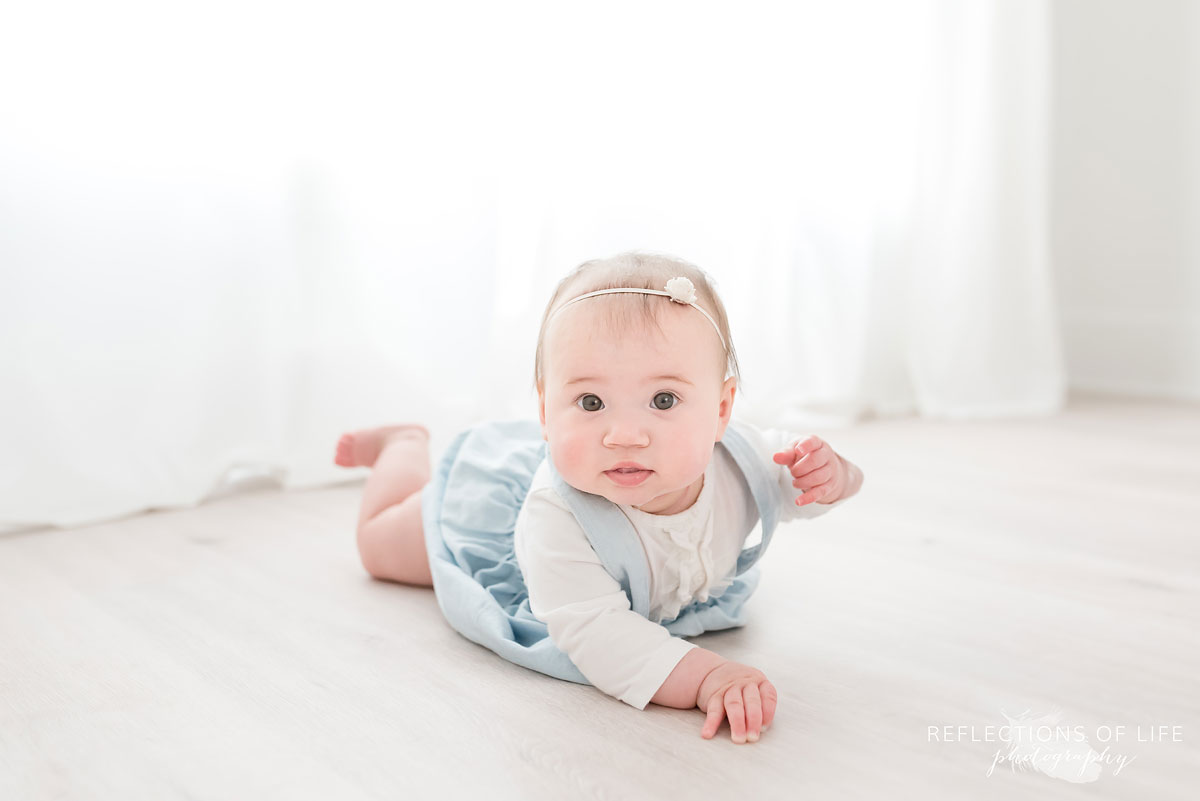 Baby lying on floor in white studio