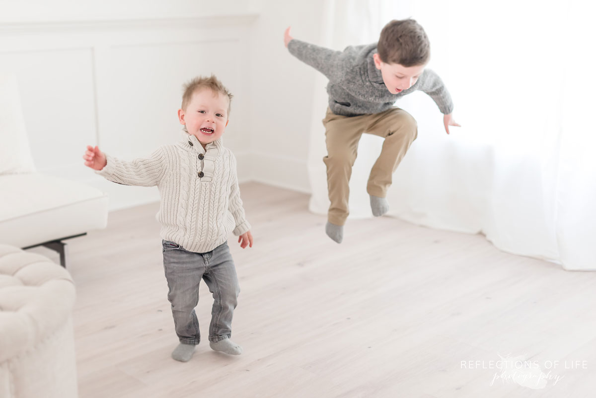 Brothers jumping in natural light studio