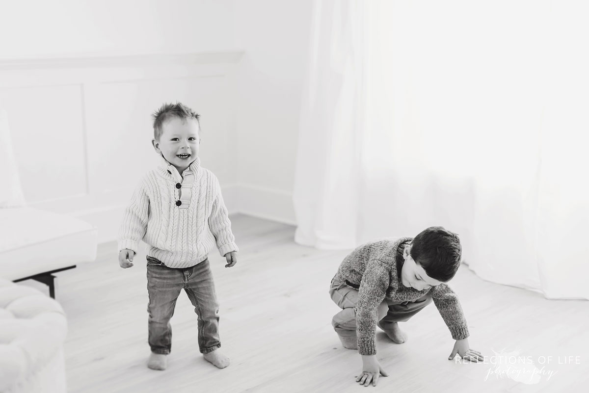 Brothers playing in natural light studio black and white
