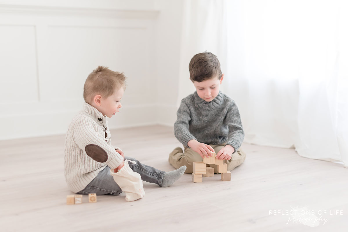 Brothers building block towers in natural light photo studio
