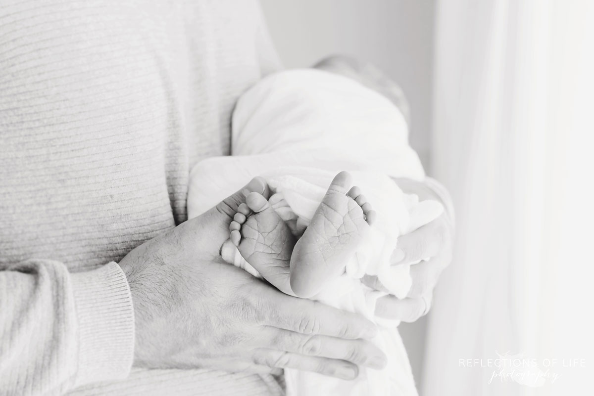 Tiny baby toes in daddy arms