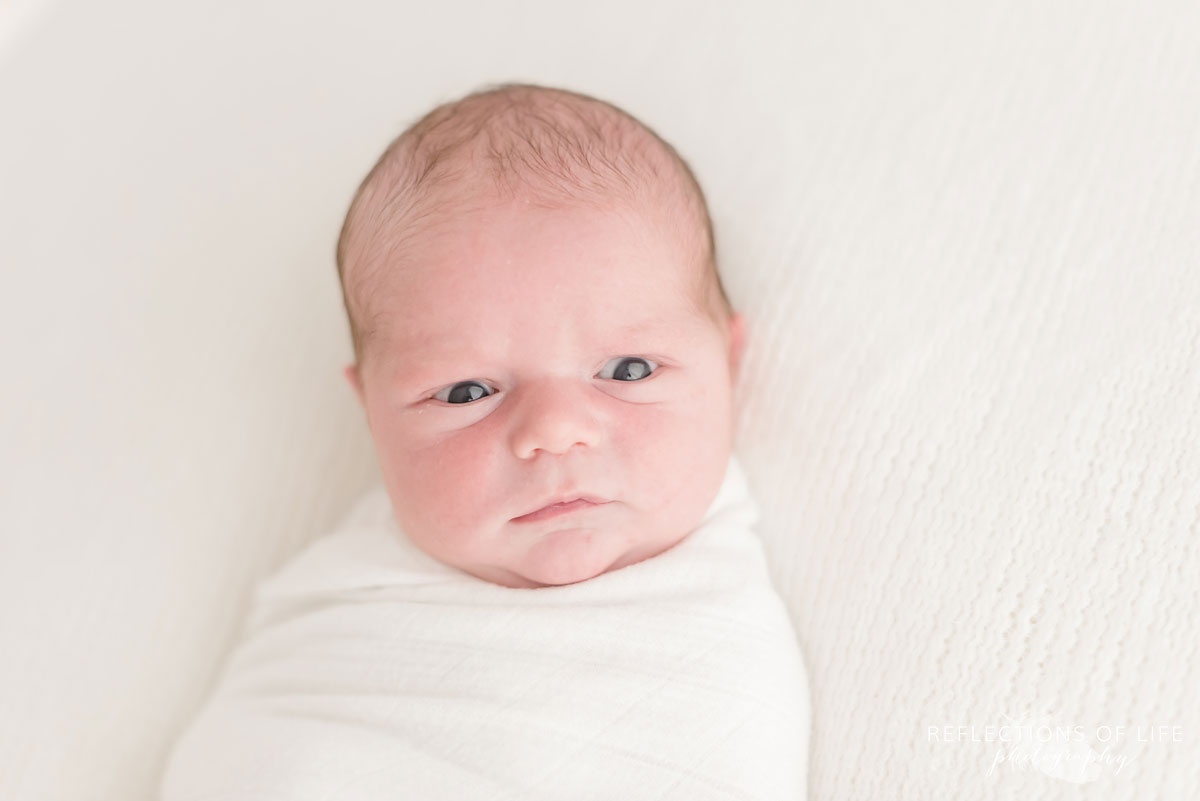 Newborn baby boy with grumpy face