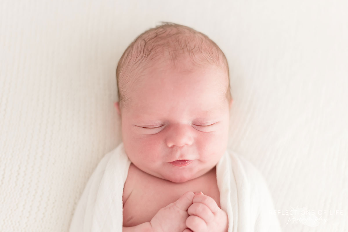 Newborn baby photo of boy smiling