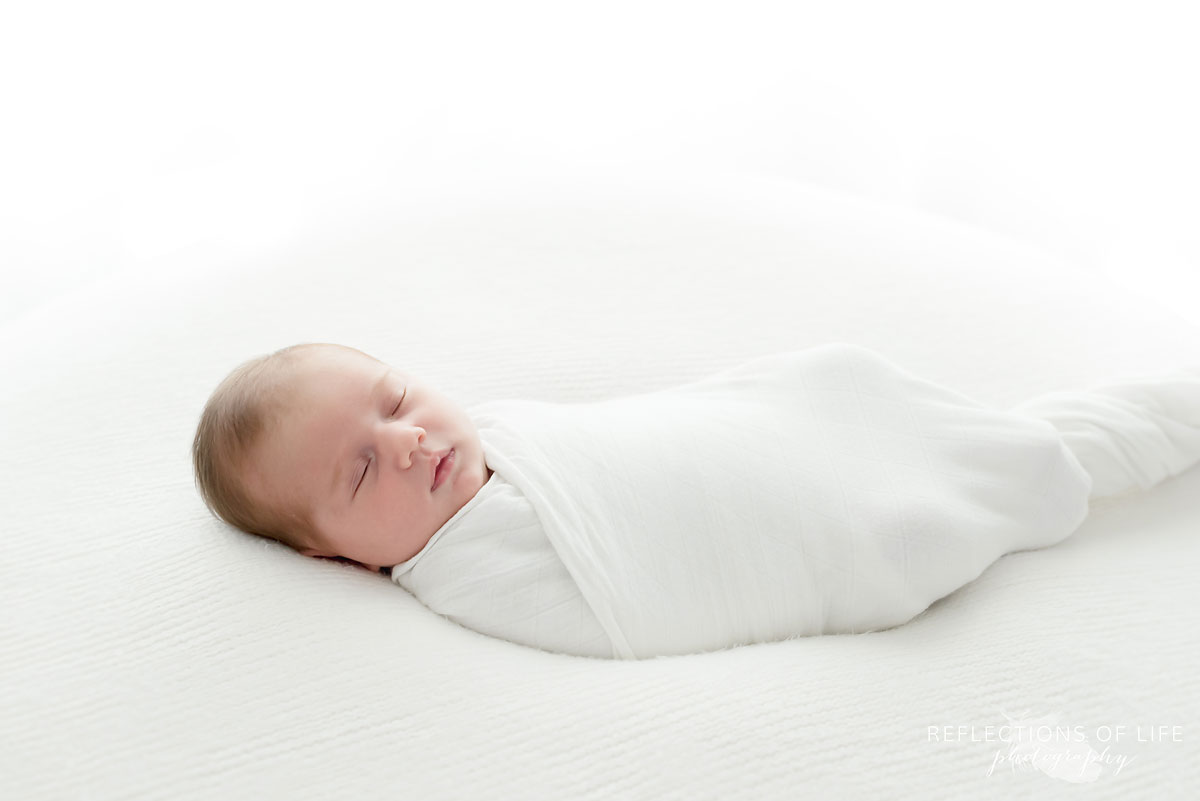 Baby girl sleepig in white studio