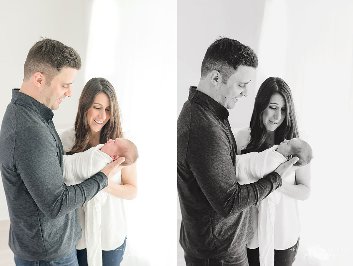 Father and mother holding baby and smiling