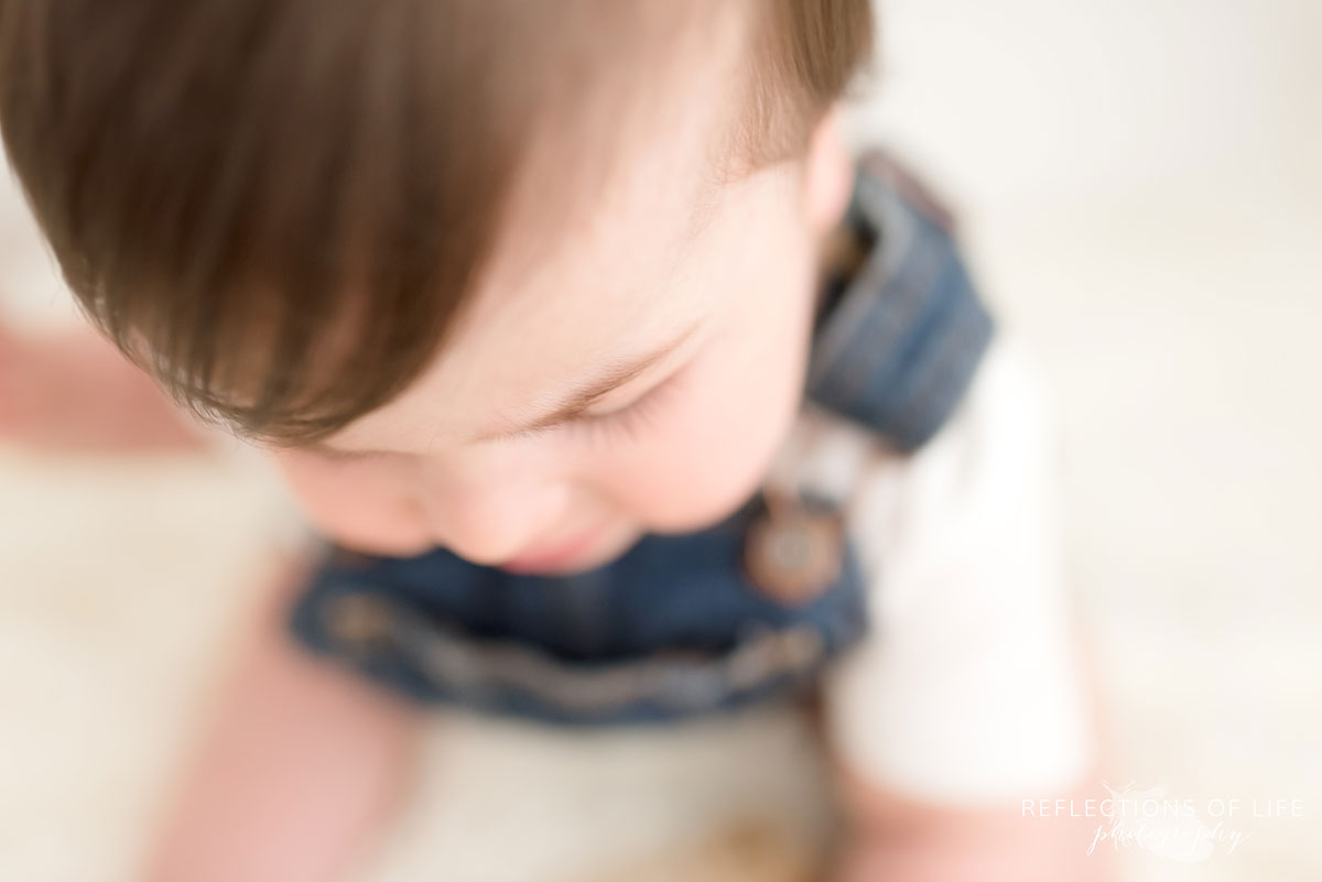 Baby with brown hair in white studio