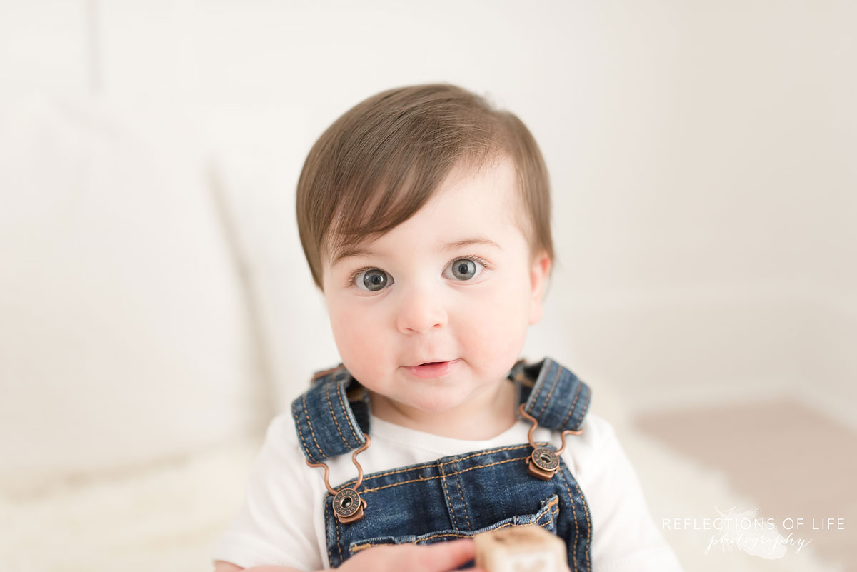 Baby looking at camera on white couch