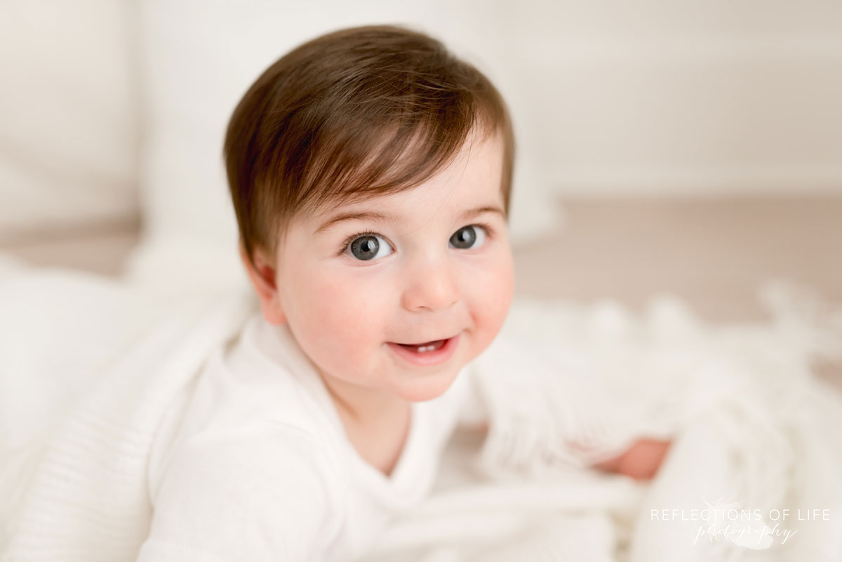 Baby smiling at camera in white studio Grimsby Ontario