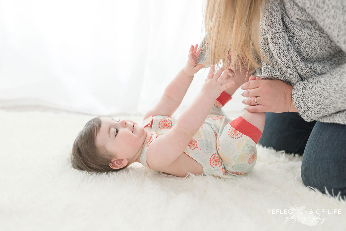 Baby grabbing mamas hair in white studio
