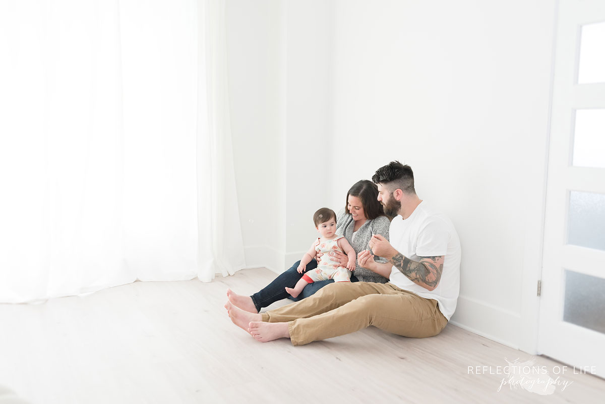 Mom dad and baby on floor smiling in Niagara