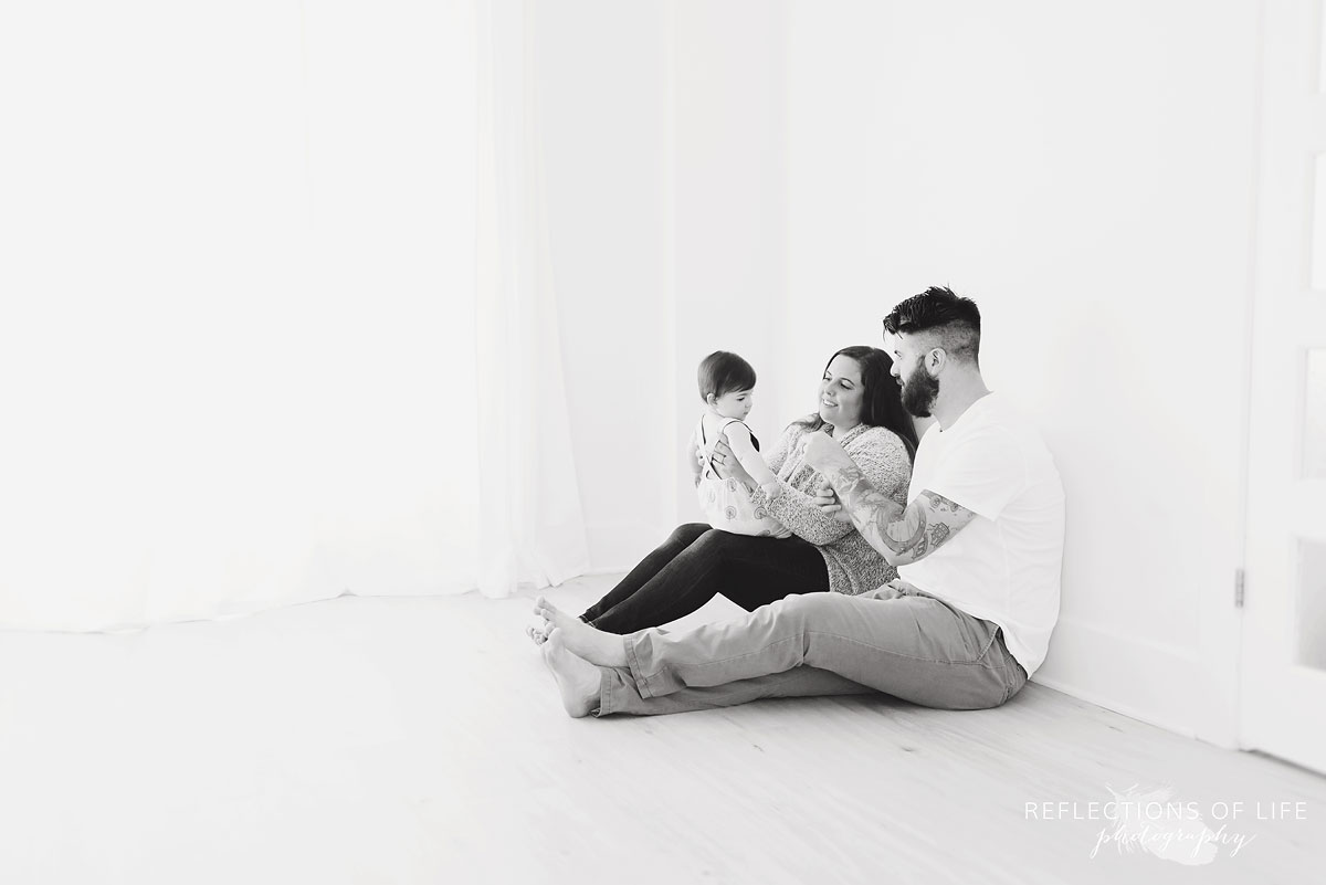 Black and white on mom dad and baby playing on floor