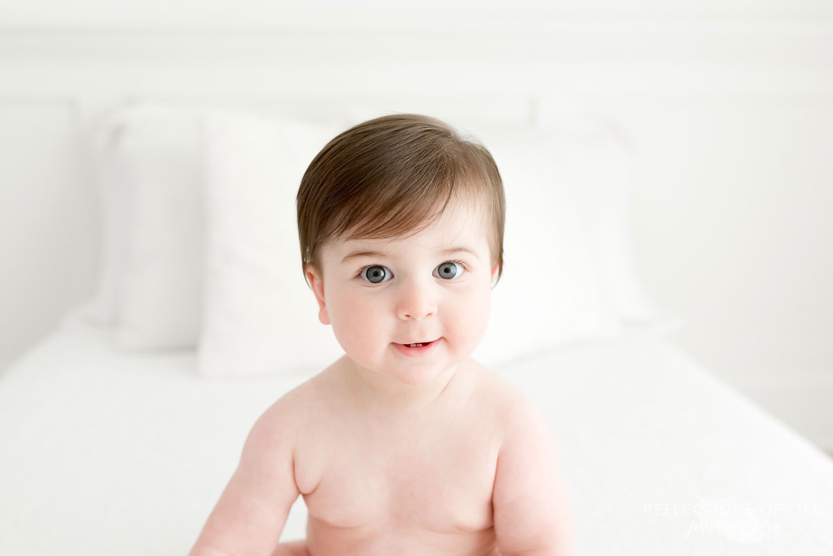Baby with no shirt on white couch
