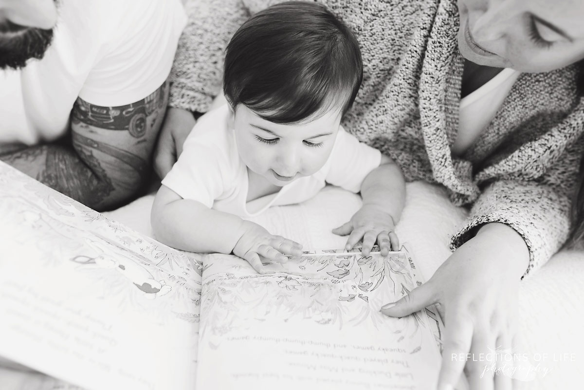 Baby looking at pictures in a book black and white
