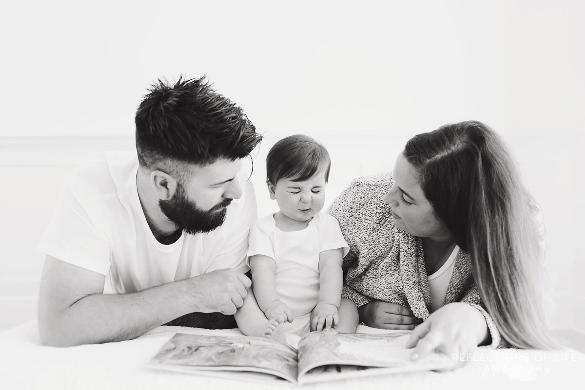 Mom and dad looking at babys reaction to reading a book