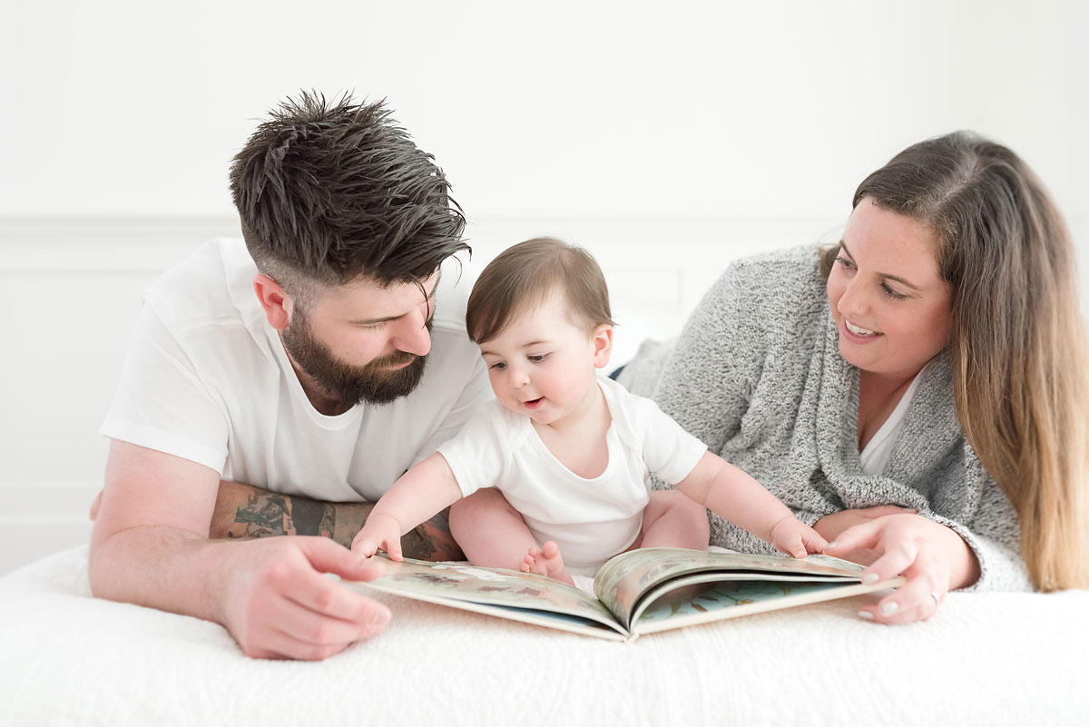 Baby closing book with mom and dad