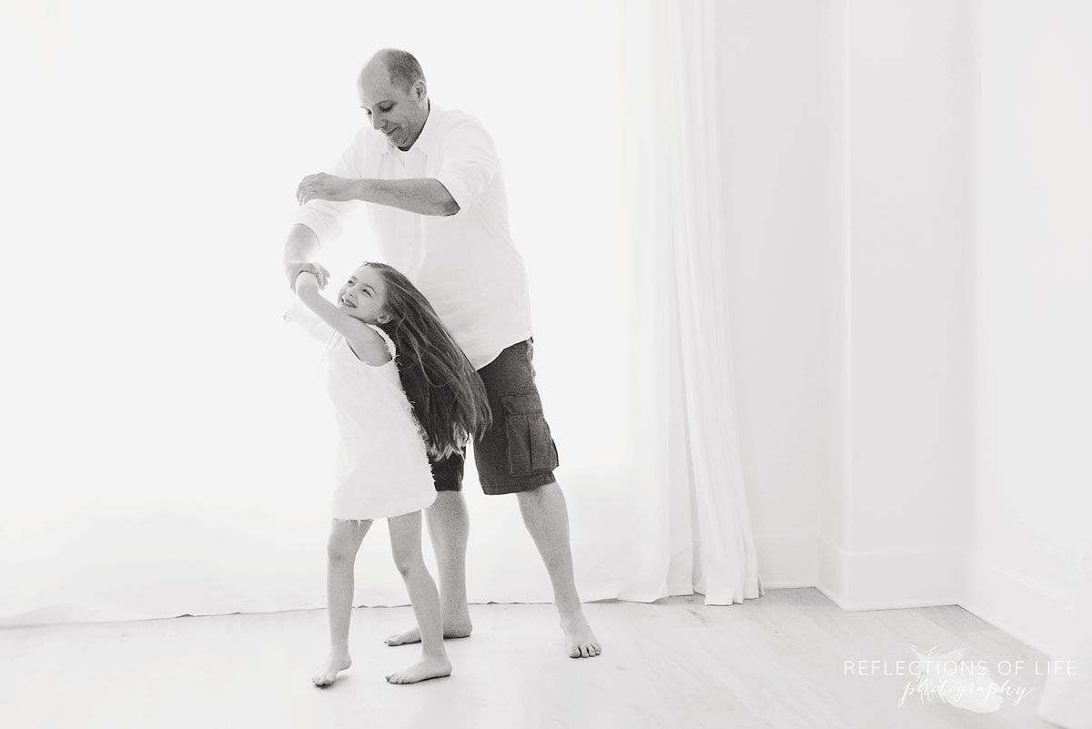 young girl and dad spinning together