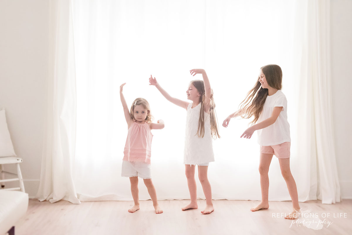 sisters playing together in front of white background