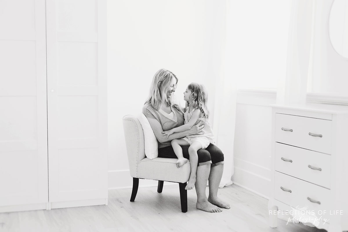 daughter sitting on mom's lap in studio