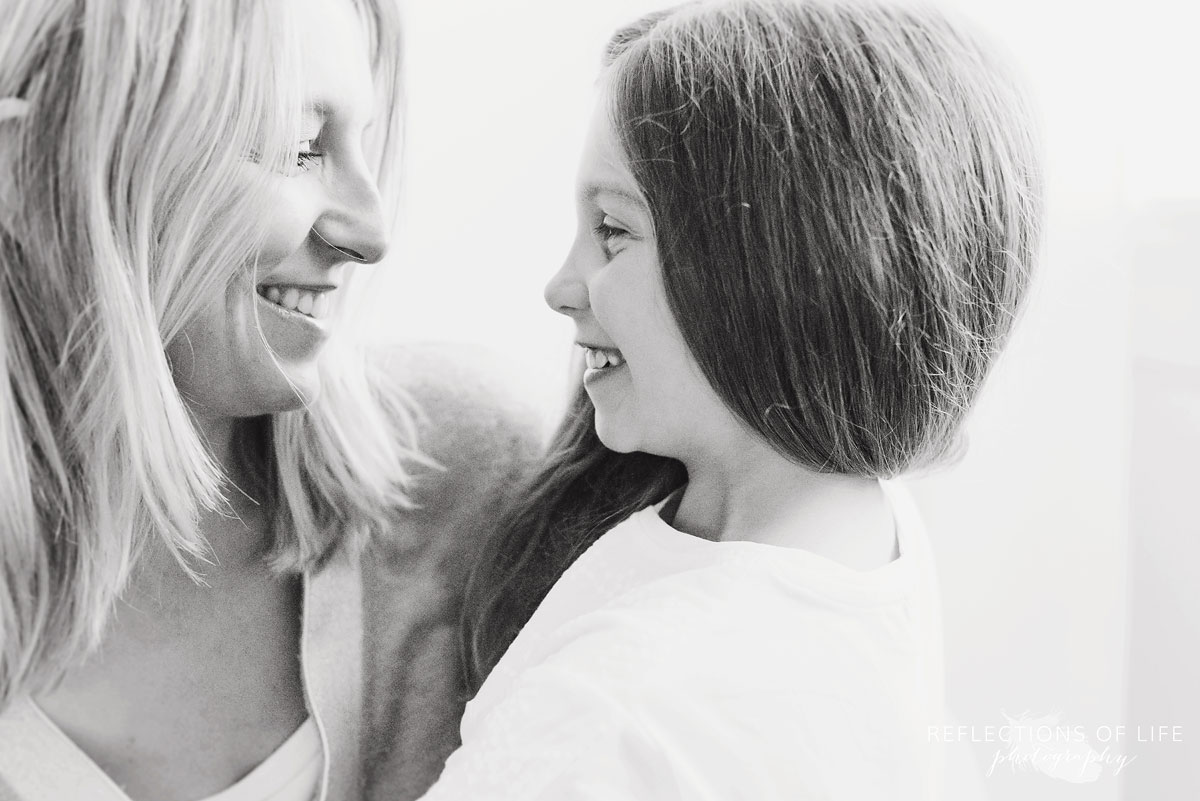 mother and daughter looking at each other white background