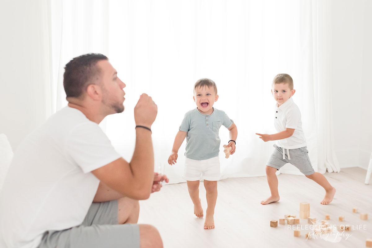 dad and sons blowing bubbles in studio