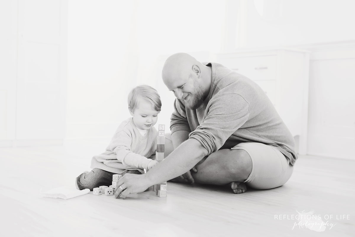 father and son on floor playing with blocks