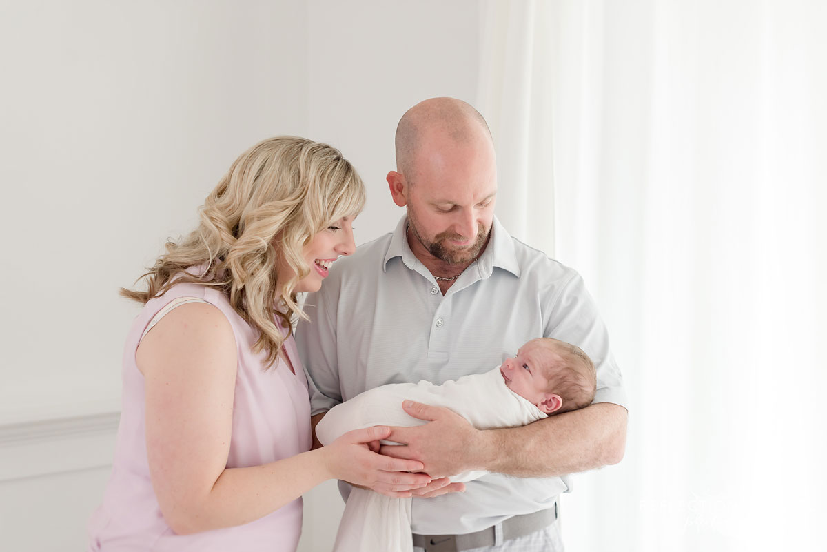 parents holding their baby boy in studio