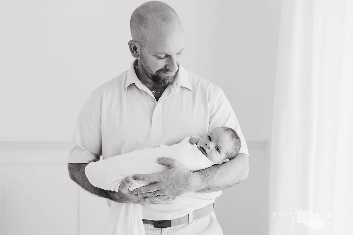 black and white portrait of dad holding baby
