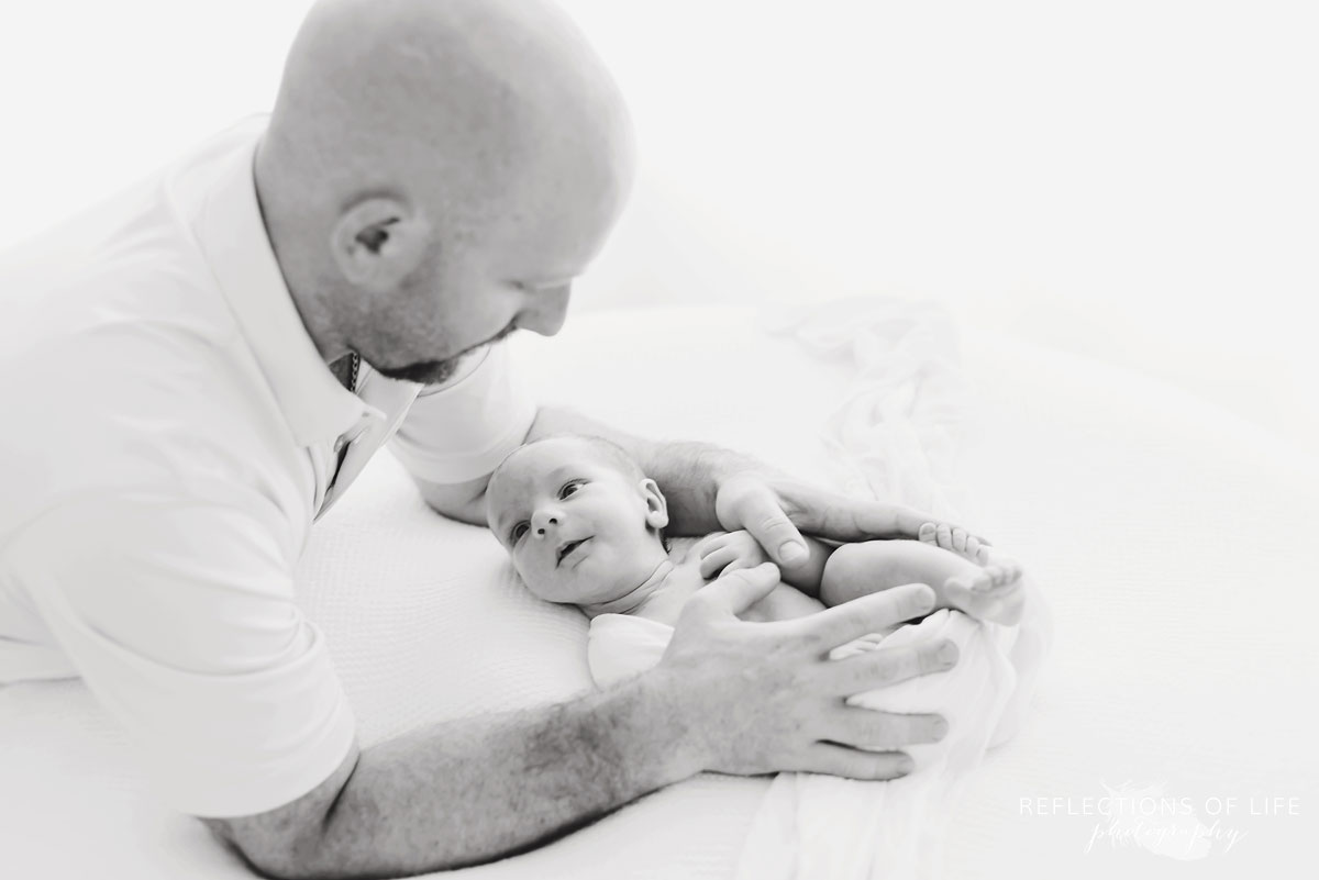 dad holding newborn baby boy black and white