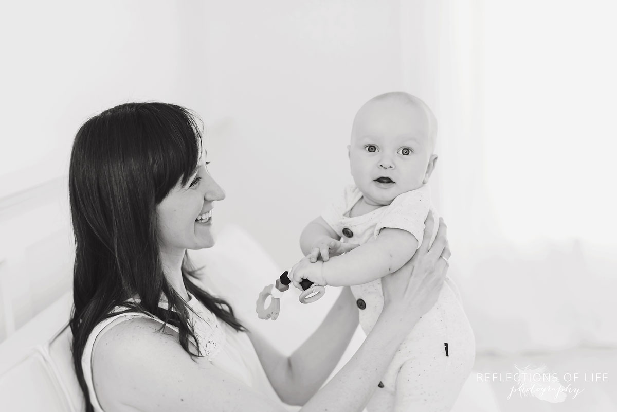 mother holding baby boy in studio on couch black and white.jpg