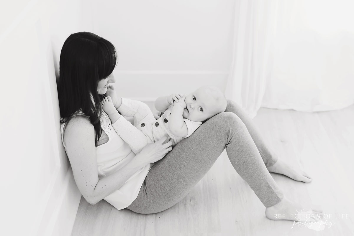mom and baby sitting together in studio black and white.jpg