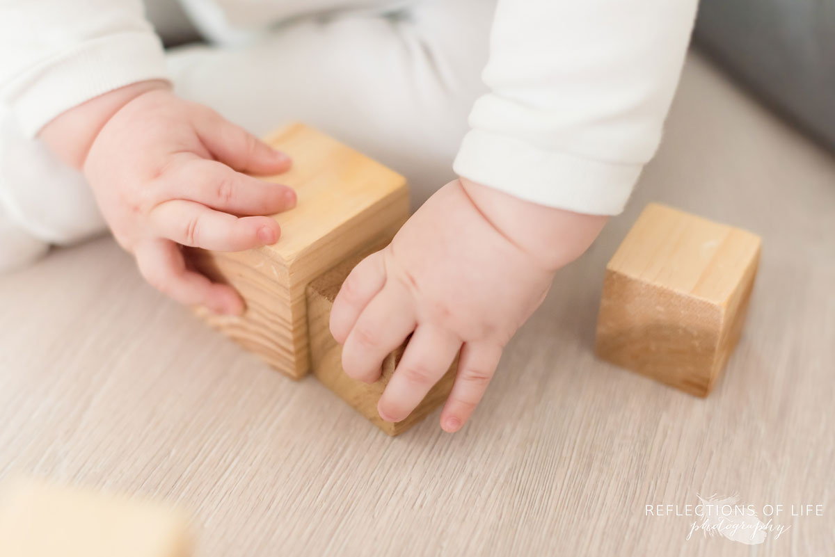 baby's hands with blocks on studio floor.jpg