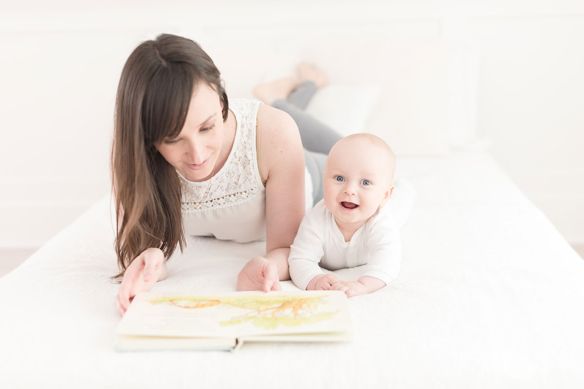 mom and baby laying on bed reading together.jpg