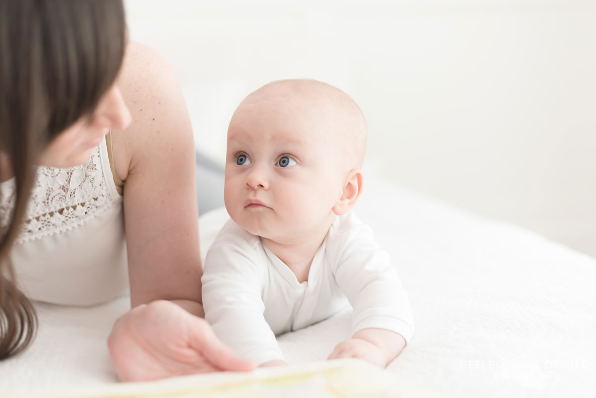 baby boy looking at mom on bed in studio.jpg