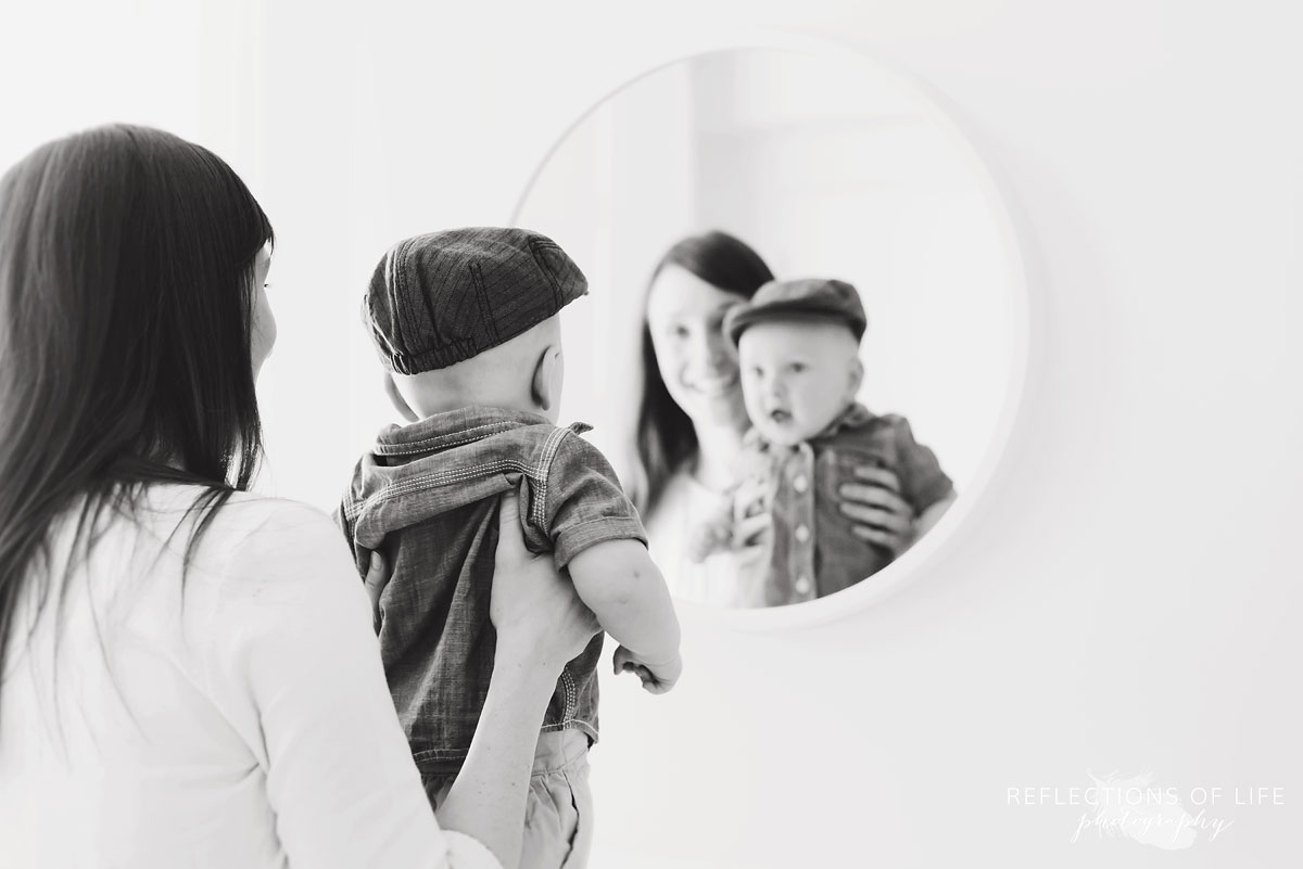 mom and baby looking in mirror in studio black and white.jpg