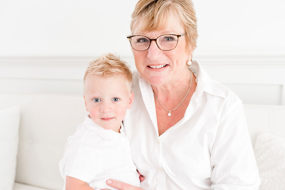 Grandma holding grandson close and smiling at the camera