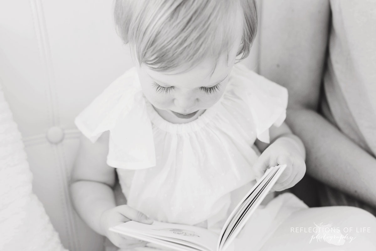 litttle girl reading a book in black and white