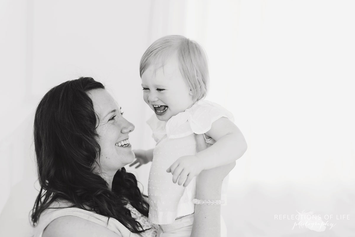 little girl and her mom laughing together